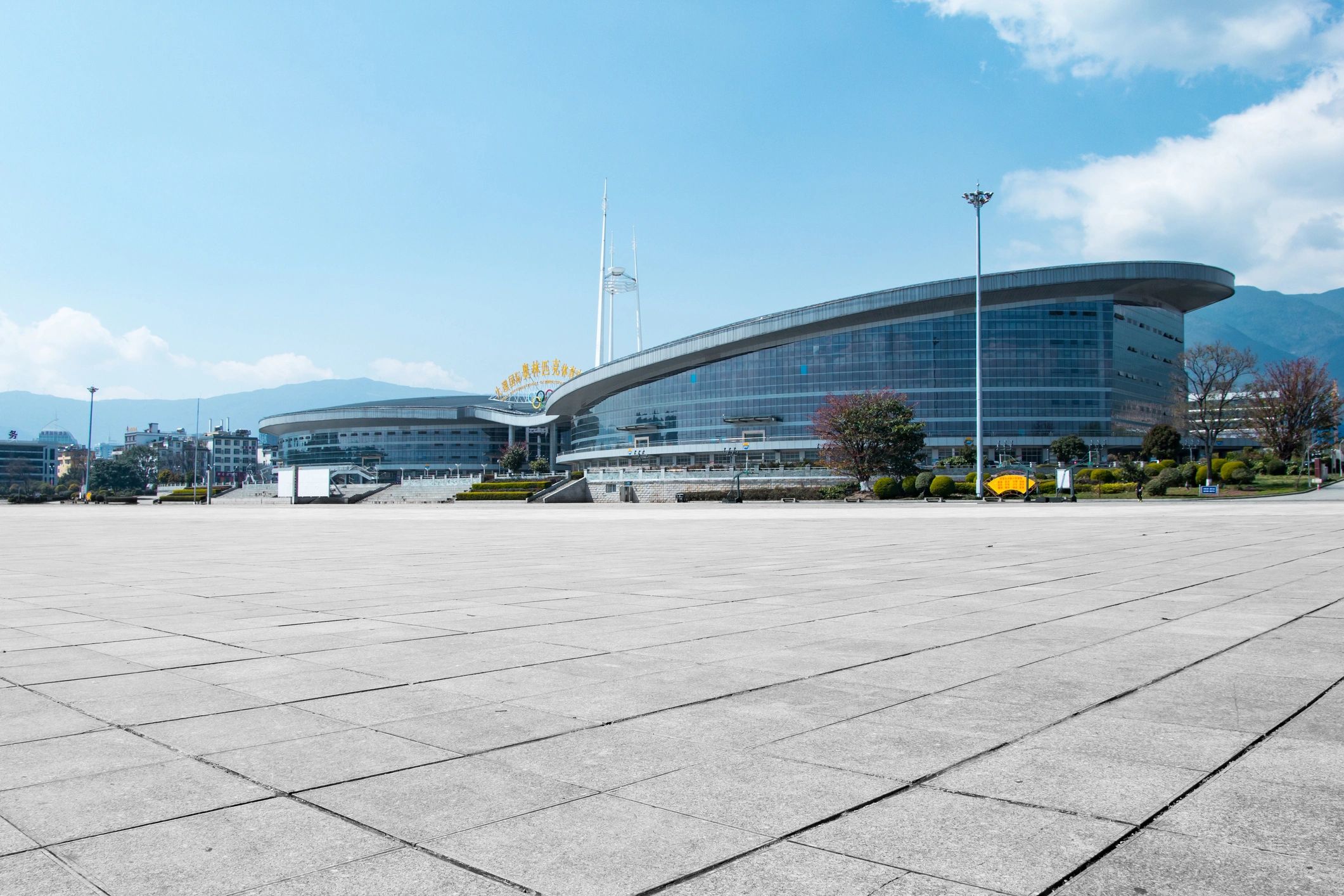 Centro de convenciones moderno con fachada de cristal y plaza abierta